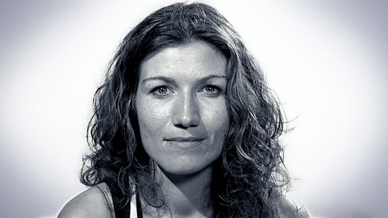 Black-and-white close-up portrait of a woman with long wavy dark hair.